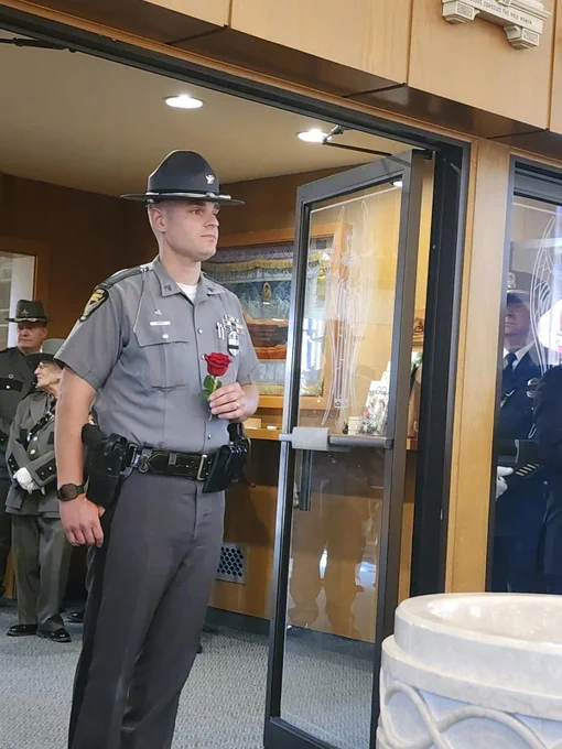 Sgt. Abbey stands in a door with a red rose during the ceremony.