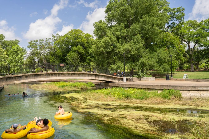 People floating in yellow tubes on the San Marcos River at Sewell Park