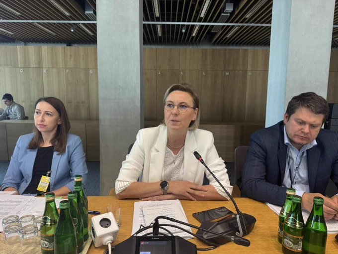 Posiedzenie Komisji Administracji i Spraw Wewnętrznych w Sejmie Rzeczypospolitej Polskiej, 9 czerwca 2026 rok. Zdjęcie sytuacyjne. Uczestnicy posiedzenia obradują w sali konferencyjnej. Wśród uczestników, od lewej, Pani Anna Czaplińska, Zastępca Dyrektora Departamentu Społeczeństwa Obywatelskiego w KPRM, Pani Minister Adriana Porowska, Wiceprzewodnicząca Komitetu do spraw Pożytku Publicznego, Sekretarz Stanu w KPRM i Pan Łukasz Jachimowicz, Dyrektor Departamentu Społeczeństwa Obywatelskiego w KPRM. Pani Minister Adriana Porowska mówi do mikrofonu. W tle widoczna sala konferencyjna.