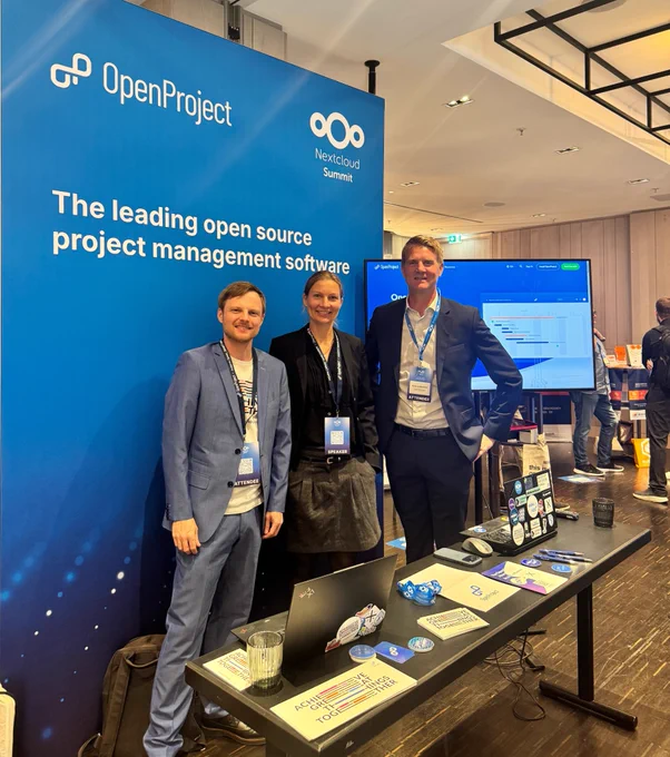 Alexander Stock, Birthe Lindenthal, and Niels Lindenthal at the OpenProject booth during the Nextcloud Summit 2026 in Munich. The team is welcoming visitors and discussing open source project management and digital sovereignty solutions.