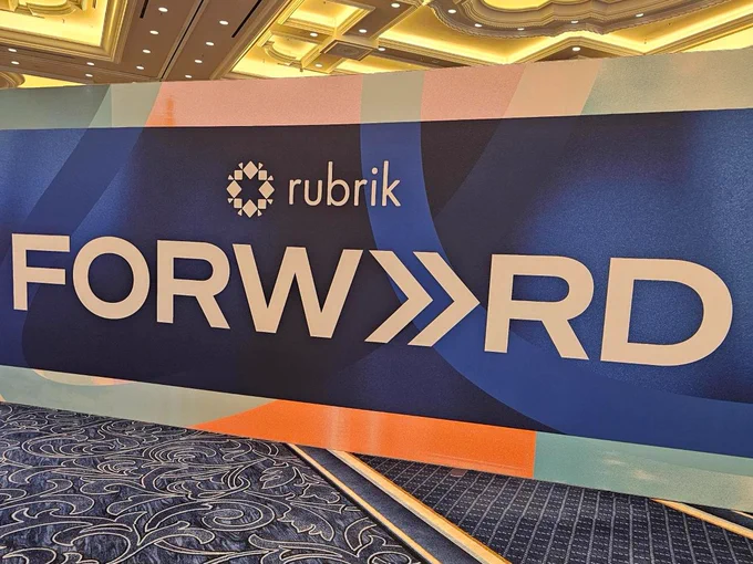 Rubrik Forward conference sign with geometric patterns in a well-lit room.