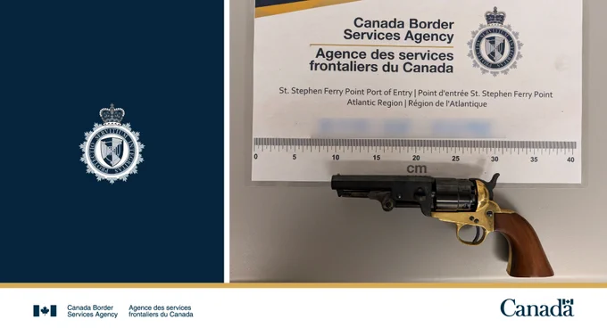 A firearm displayed on a table with a CBSA sign.