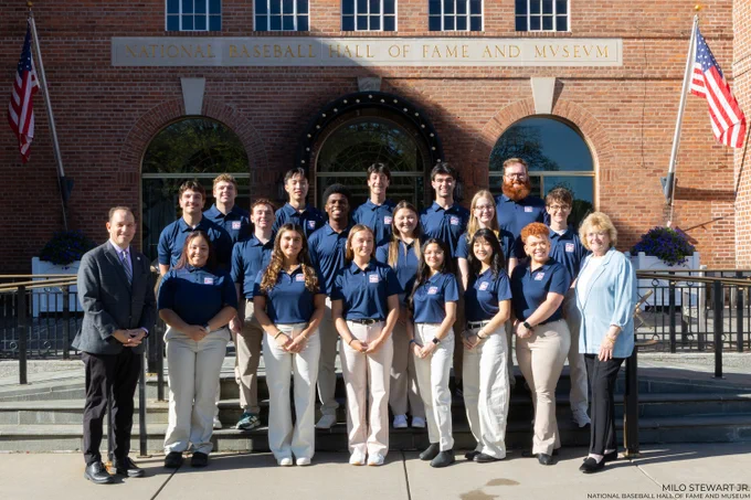 Seventeen students stand in three rows in front of the Museum wearing blue polo shirts, joined by Hall of Fame President Josh Rawitch (first row, end left) and Peggy Steele (first row, end right).

Milo Stewart Jr./National Baseball Hall of Fame and Museum