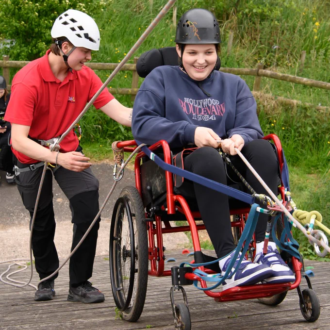 Photo of a young wheelchair user abseiling during a Back Up Youth Advisory Group weekend.