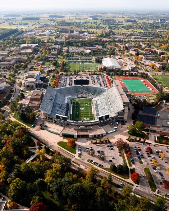 Aerial view of Spartan Stadium surrounded by fall colors, campus buildings and athletic fields.