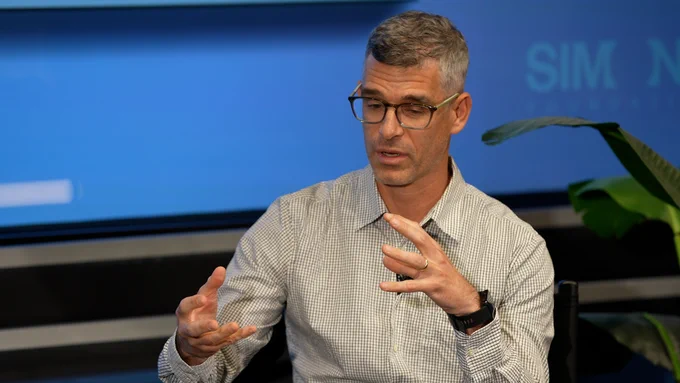Man speaking in front of screen