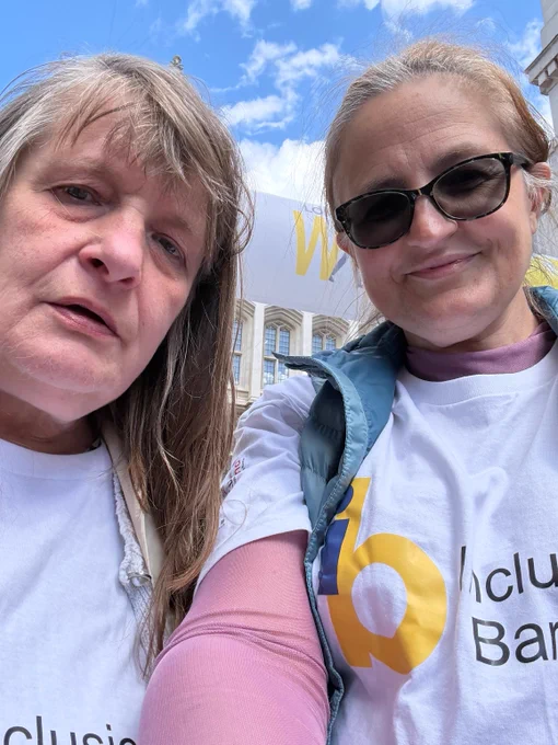 Photo of Caroline (L) and Keely (R), two middle-aged white women wearing Inclusion Barnet t-shirts. 