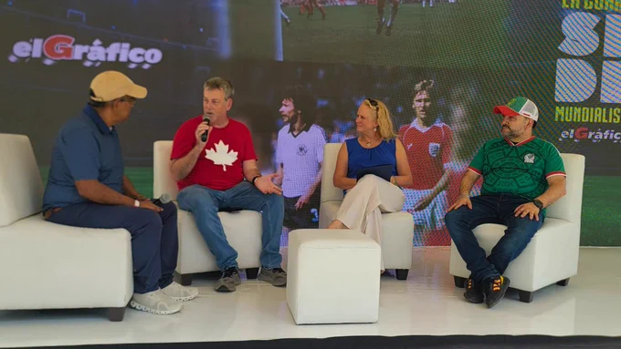 Panel discussion at La Feria Futbolera featuring four speakers on stage, including a representative from the Embassy of Canada wearing a red shirt with a white maple leaf.