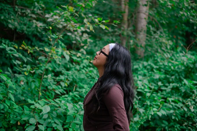 Woman basking in the atmosphere of nature at a forest bathing session.
