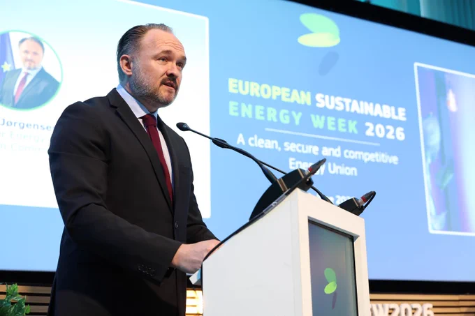 Commissioner Dan Jørgensen speaks at a lectern during the European Sustainable Energy Week 2026. A screen behind him displays EUSEW branding.