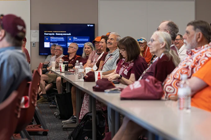Group of alumni sitting at a table smiling 