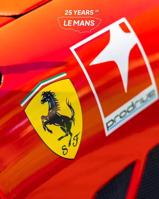 Close up of Ferrari prancing horse badge alongside Prodrive logo on the bodywork of a Prodrive Ferrari 550 Maranello GTS, bright red paintwork with reflections.