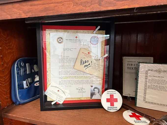 Red Cross memorabilia inside of a shadowbox, on a shelf