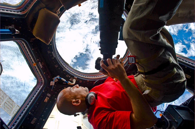 ESA astronaut Luca Parmitano waiting for a target on Earth to photograph in the Cupola observatory on the International Space Station.