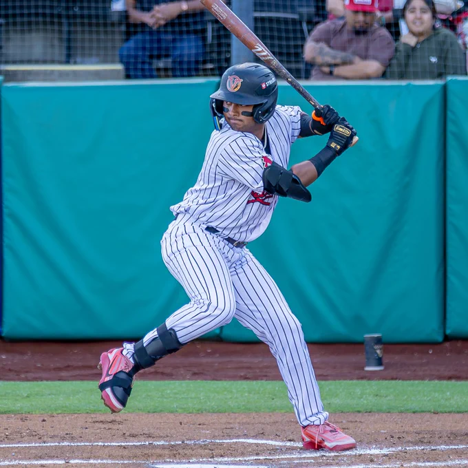 Kayson Cunningham bats with in a pinstriped Visalia Rawhide uniform