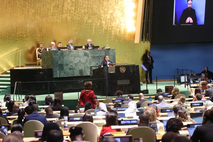 A woman delivers remarks during the opening session of COSP19 in the General Assembly Hall.