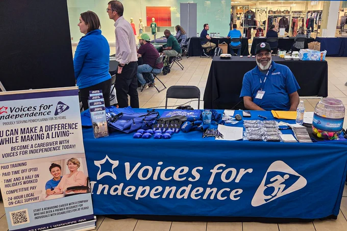 VFI Hiring and Recruitment Specialist, Khyl, smiles while seated at the VFI table at the 814 Job Fair.
