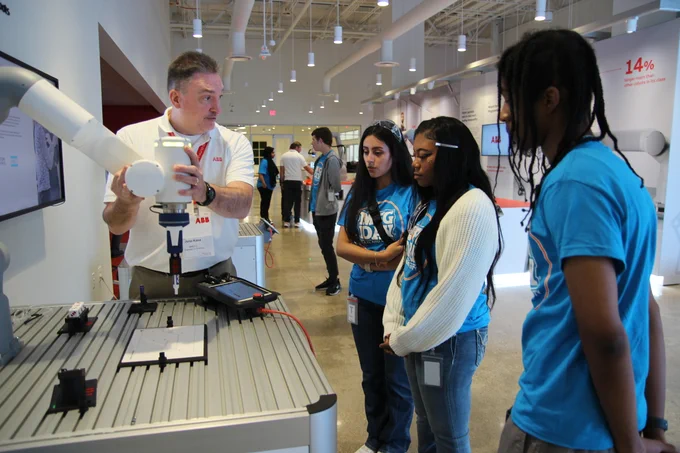 Students on a Manufacturing Day tour talking with an employee from ABB.