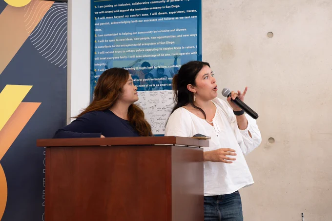 Two people looking up, one speaking into a microphone