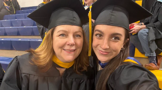 Kate Fallon Manupelli ‘92, M’26 and Kayleigh Manupelli ‘25, M’26 smile before Merrimack College's Commencement. 