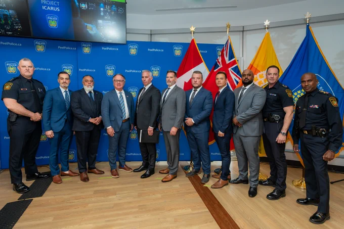 Group of individuals posed in front of Peel Police backdrop