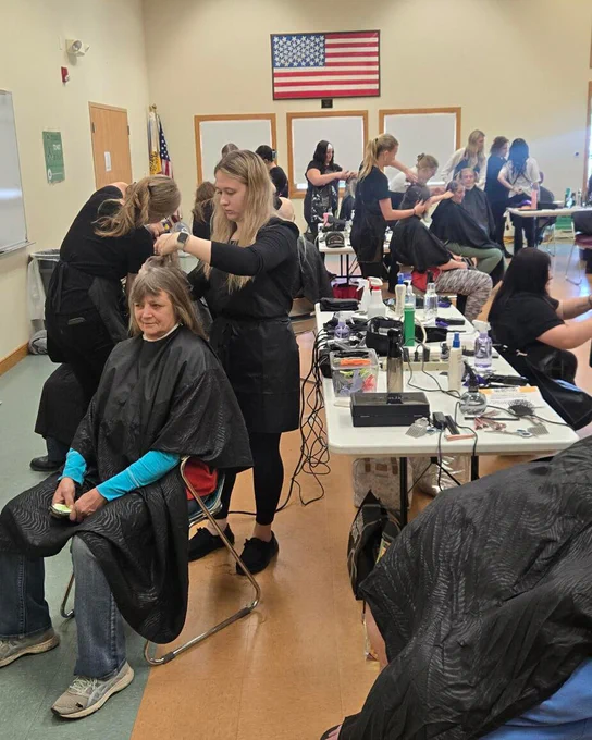 Cosmetology students provide free haircuts to community members during an Adams County wellness event.