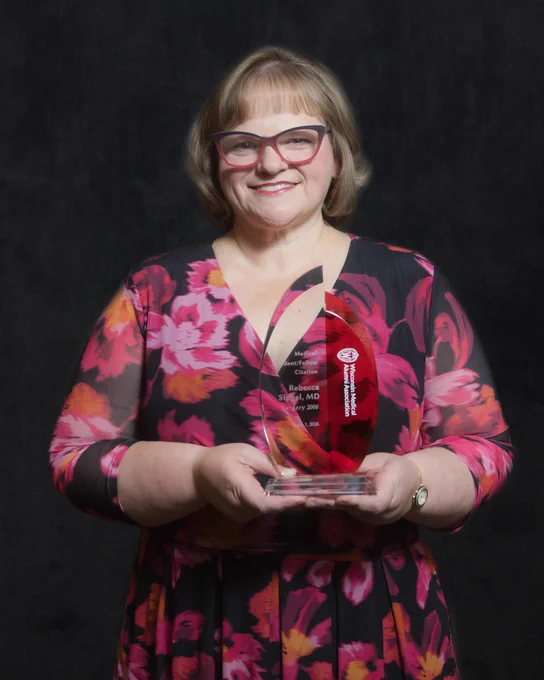 Dr. Rebecca Sippel holds her award from the Wisconsin Medical Alumni Association