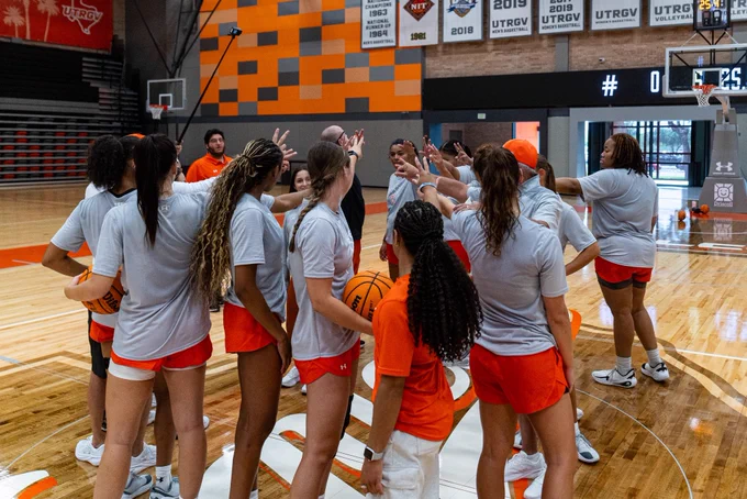 Team huddle before practice begins as players and coaches gather at center court on the first day of summer workouts.