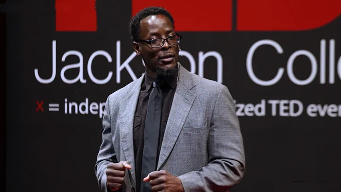 Speaker Roland Anderson delivering a TEDx talk at Jackson College on stage.