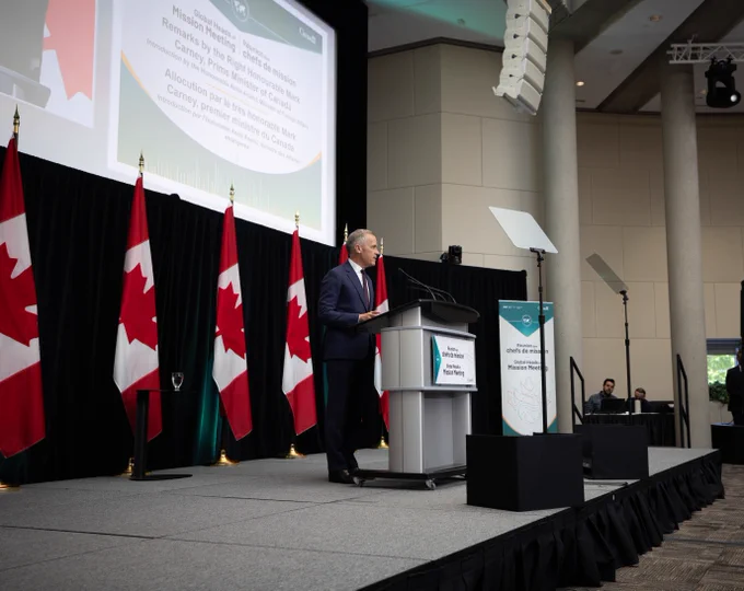 Le premier ministre Mark Carney, derrière un lutrin, prononce une allocution devant les chefs de mission du Canada lors d’une rencontre à Ottawa. 
