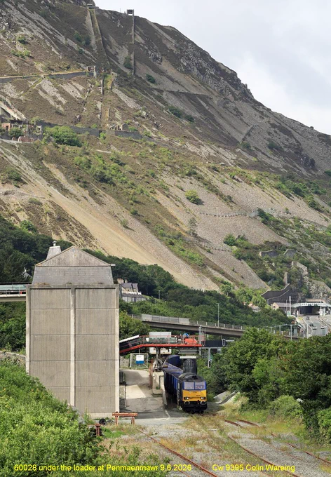 60028 under the loader at Penmaenmawr 9.6.2026  
         
Cappagh Group locomotive no 60028 is at the head of a stone train waiting to be loaded at Penmaenmawr on the North Wales coast on Tuesday 9.6.2026.
Once the train is loaded it will have around 2000 tonnes of stone with in the wagons that has come from the nearby quarry. 
According to Real Times Trains the train, once loaded was due to leave here as the 14.54 hrs service to Leyland under Headcode or train reporting no 6N91. 
However, that got cancelled and the train was rescheduled as the 19.53 to the HS2 railhead at Quainton in Buckinghamshire where the stone will be unloaded and be used on the construction of HS2.  
DCR is DC Rail, a rail freight company providing mainly bulk services for construction, energy and manufacturing across the UK. 
The locomotive, 60028 carries distinctive blue livery of the Cappagh Group who own it though it is operated by DC Rail
It is running under the head code or train reporting no 6A26. 
9.6.2