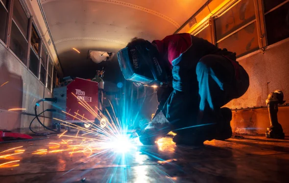 Person welding inside a bus. 