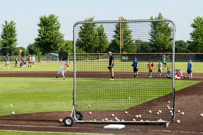 Youth baseball campers participate in fielding drills on the UIS Baseball field during summer camp.