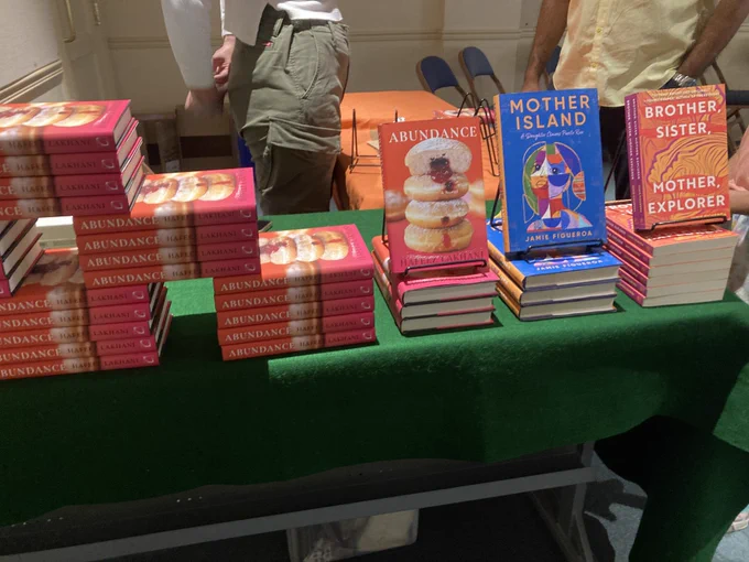 Stacks of the books Abundance, Mother Island, and Brother Sister Mother Explorer on a table.