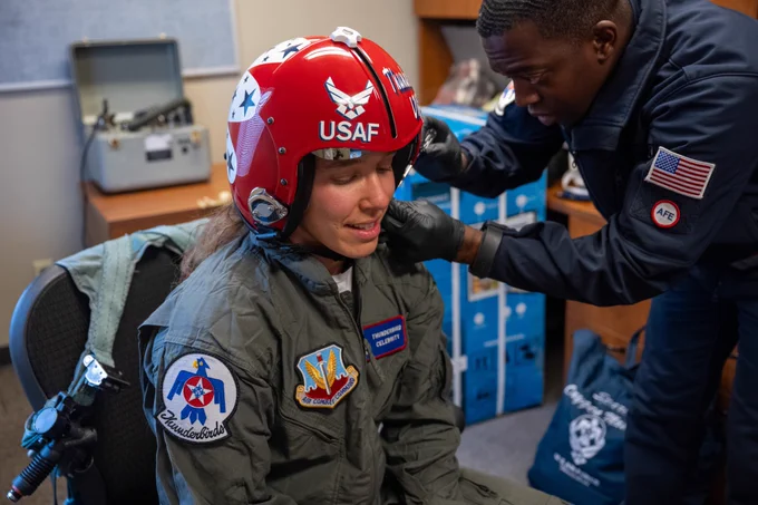 The Academy’s Civilian Instructor of the Year gets her helmet properly fitted for her head.