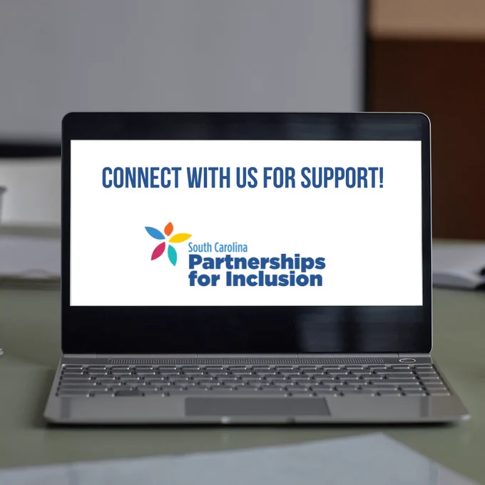 An open laptop computer on a desk. The laptop's screen is white with dark blue text that reads: "Connect With Us For Support!" The South Carolina Partnerships for Inclusion logo is at the bottom of the laptop's screen.