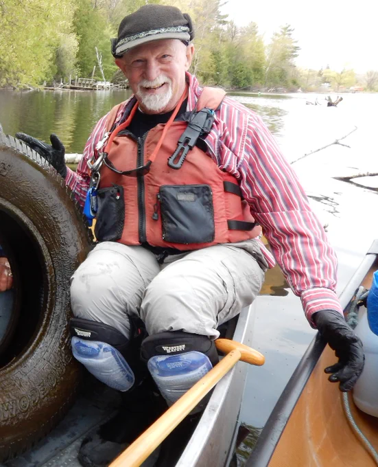Norm Fred, founder of Boardman River Clean Sweep, sits in a
canoe with a tire removed from the Boardman River at a river cleanup event funded by MiCorps. Credit: Boardman River Clean Sweep.