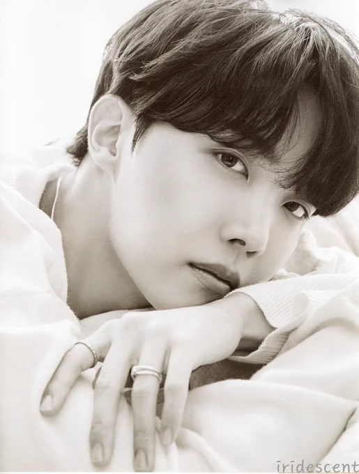 j-hope from d'icon magazine in 2020. he's in black and white, head pillowed on his arms, looking gently into the camera.