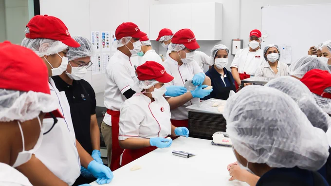 รูปที่ 2: ภาพหมู่ของทีมงานจาก Millennium Hilton Bangkok ทำขนมปังร่วมกับผู้พิการ

Picture 2: Group photo of team members from Millennium Hilton Bangkok baking the bakeries with persons with disabilities.