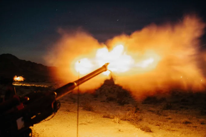 U.S. Marines assigned to Battalion Landing Team 2/4, 13th Marine Expeditionary Unit, fire an M777 howitzer in support of a nighttime fire mission during unit-level training at Marine Corps Air Ground Combat Center Twentynine Palms, California, May 29, 2026. Unit-level training allows the artillery battery to hone fundamental skills and fire-direction procedures, forging a lethal and cohesive team prepared to provide critical fire support for the 13th MEU during complex and austere operations. (U.S. Marine Corps photo by Sgt. Mary R. Jenni)

