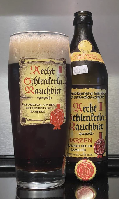 It's a bottle of Aecht Schlenkerla Rauchbier and the matching glass!  The beer is from Bamberg, Germany, and brewed using smoked malts... thus making it a smoke beer or "rauchbier".  The smoke is how you know the beer is fire.