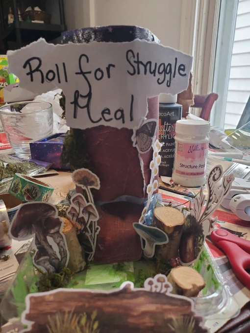 A Woodland themed DIY dice  with "Roll For Struggle Meal" printed on it