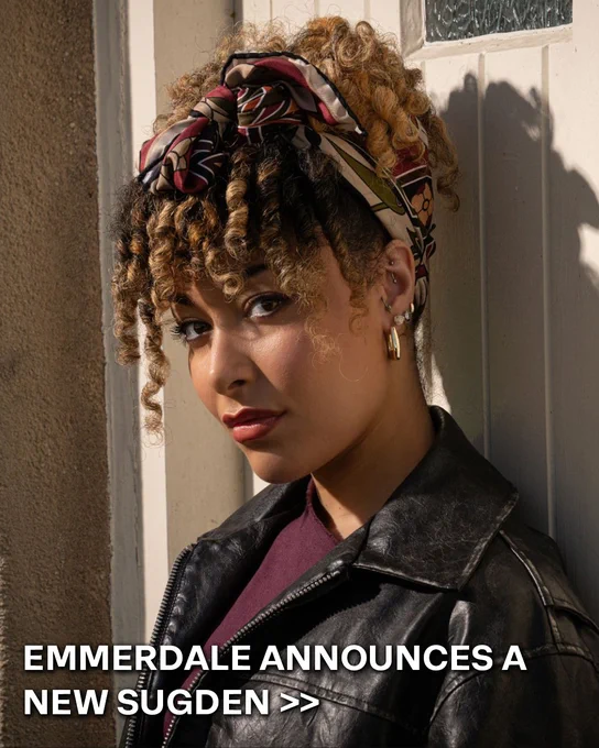 Picture of new Emmerdale character Serena Sugden.\n\nShe has brown curly hair that's tied up.\n\nWearing a black leather jacket and a red top