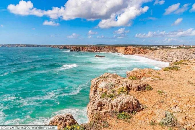 Waves crashing against the rocky coastline of Sangres on the Algarve, the southernmost point on our portuguese road trip