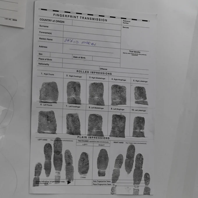 the image depicts a fingerprint transmission form showing rolled and plain impressions of all fingers with handwritten surname and personal details fields.