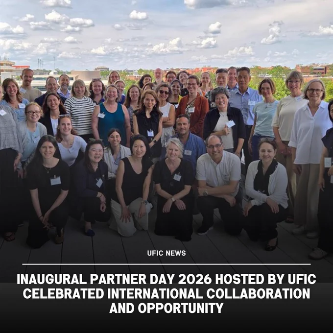 Large group of diverse professionals posing outdoors on a terrace under a partly cloudy sky during UFIC's Inaugural Partner Day 2026 event.