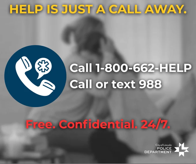 An advertisement by City of Lincoln Police Department featuring a blurred individual sitting with their head in their hands. Text reads "HELP IS JUST A CALL AWAY. Call 1-800-662-HELP or text 988. Free. Confidential. 24/7." Includes icons of a phone and a text bubble.