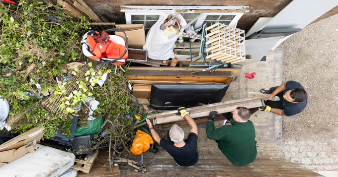 Aerial view of three people loading items into a Mega Skip