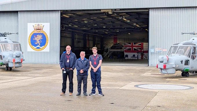 A photo of three male STS Defence employees outside the 760 naval air squadron hangar at HMS Sultan.