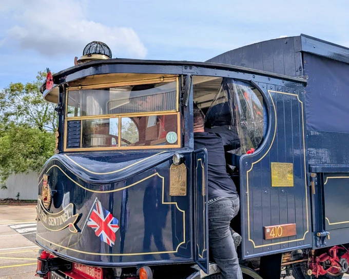 A male STS Defence apprentice inside the 
HMS Sultan's Super Sentinel Steam Waggon. He is being shown by the personnel who looks after it.